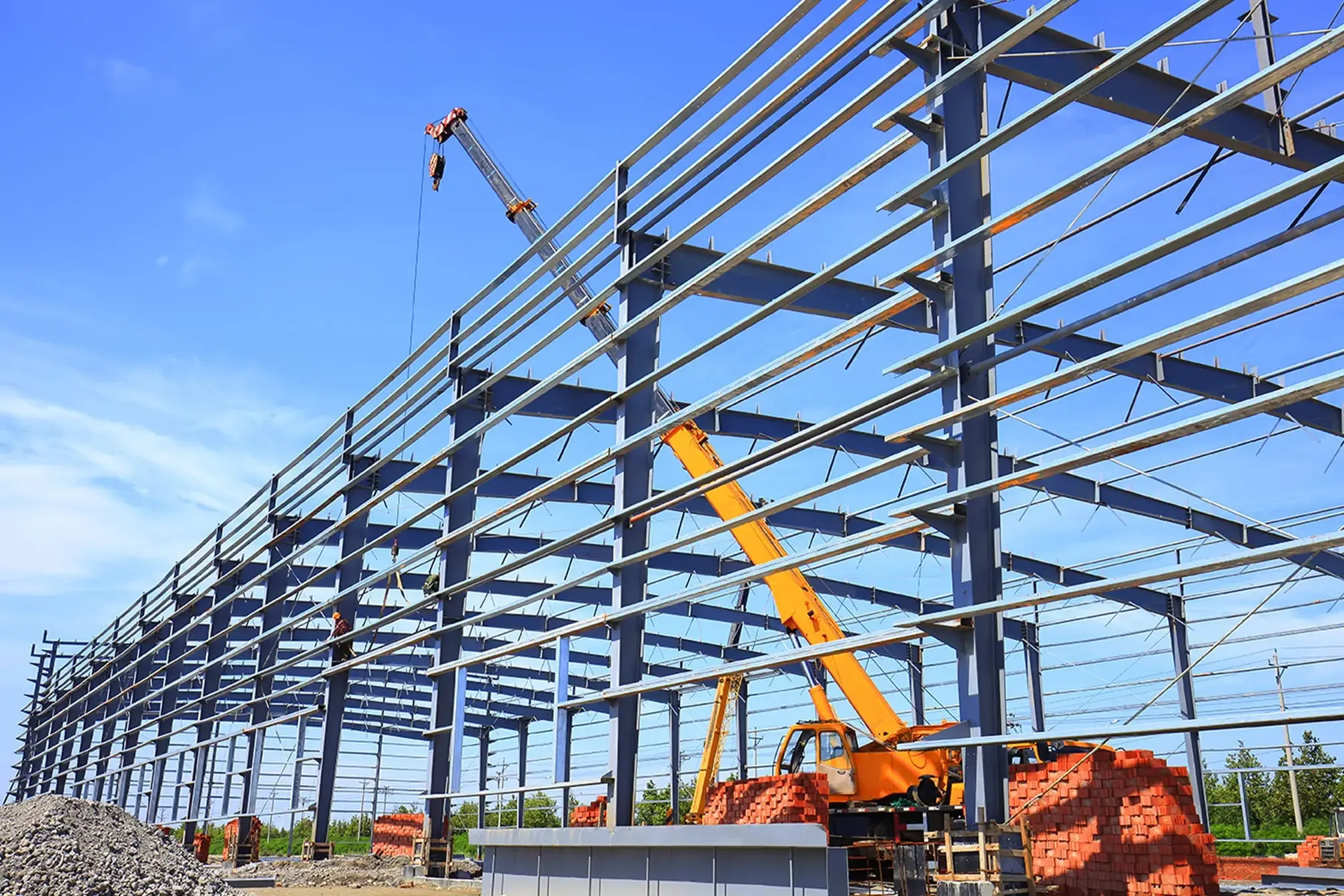 Steel building erection crew assembling primary frame structure